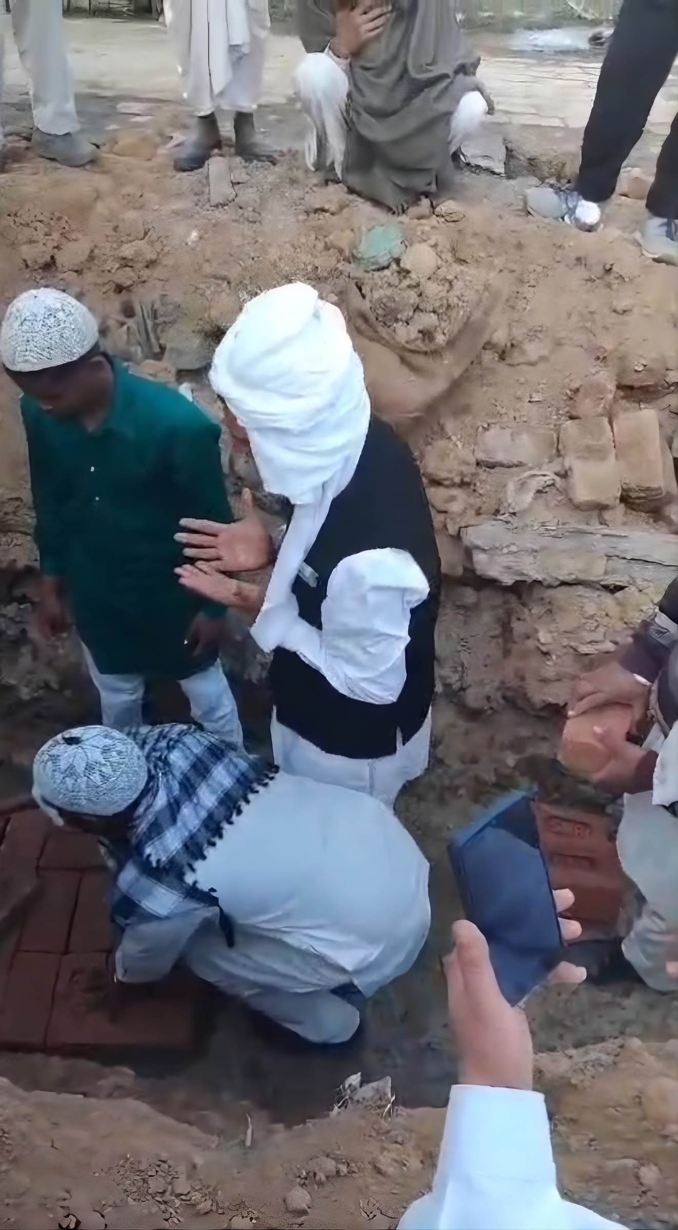A person praying after placing a brick